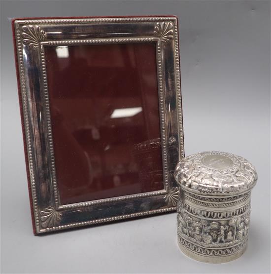An Indian repousse white metal jar and cover and a silver plated photograph frame.